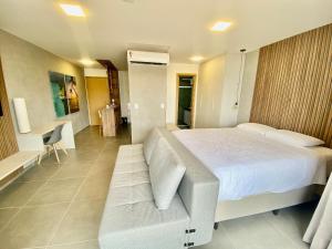 1 dormitorio con cama blanca y sofá en Edifício Loft Apto 502 ER Hospedagens, en Maceió