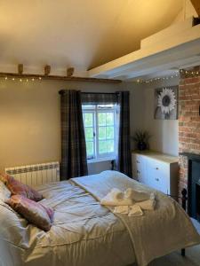 1 dormitorio con 1 cama con toallas en Pieman's Cottage - Pulborough, West Sussex Cottage - sunny courtyard, en Pulborough