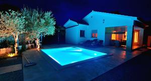 una piscina nel cortile di una casa di notte di Villa Nevera a Omišalj (Castelmuschio)