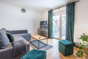 a living room with a couch and a table at Arbio I Cozy Apartments Augsburg-Lechhausen in Augsburg