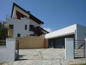 a white house with a garage and stairs at Villa Stadi in Nikiti