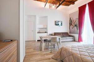 Toto e Peppino luxury rooms في نابولي: غرفة نوم بسرير وطاولة واريكة