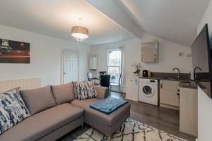 a living room with a couch and a kitchen at Crosby Apartments in Liverpool