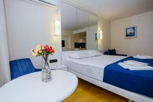 Un dormitorio con una cama y una mesa con un jarrón de flores en Orbi City Sea View - Special Category, en Batumi