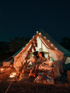 two people sitting at a table in a tent at Sa Mola Experience TENDA in Escolca