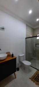 uma casa de banho com um WC e uma cabina de duche em vidro. em Pousada Graboschii, 300mt da praia do Refúgio em Aracaju