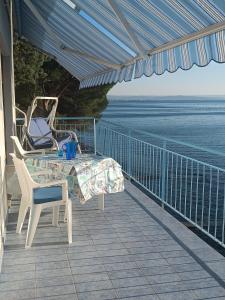 a balcony with a table and chairs and the ocean at Locazione Turistica Sul Mare Strada Costiera 244, Trieste in Santa Croce Mare