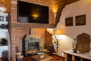 sala de estar con chimenea y TV de pantalla plana en Casa da Ti´Lola, en Évora