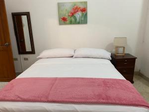 Un dormitorio con una cama con una manta roja. en Casa Olguita, en Manta