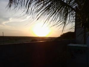einen Sonnenuntergang über einem Zaun mit Sonnenuntergang in der Ferne in der Unterkunft Casa L&A in Aracati