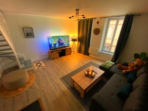 een woonkamer met een bank en een tv bij Super Appartement T3 proche gare in Sens