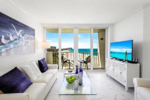 a living room with a couch and a tv at Modern beachfront condo with pool, gym and tennis in Marco Island