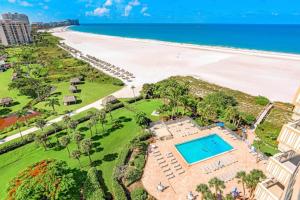 an aerial view of the beach and the pool at Modern beachfront condo with pool, gym and tennis in Marco Island