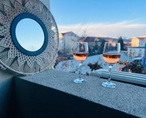 two glasses of wine sitting on a window sill at Paris Residence Targu -Jiu in Târgu Jiu