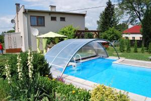 a swimming pool with a cover next to a house at Ferienhaus Hlidek in Nová Lhota