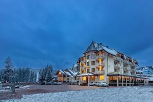 a large building with cars parked in a parking lot at Continental in Bukovel