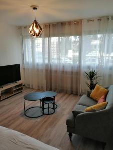 a living room with a couch and a table at Orion - SILS Coquet studio proche des commodités et transports in Hérouville-Saint-Clair