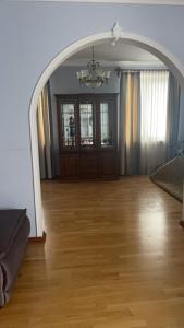 un arco in un soggiorno con pavimento in legno di Lux House a Černivci