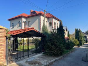 uma casa velha com um portão em frente em Lux House em Chernivtsi