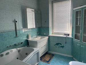 a bathroom with a tub and a sink and a mirror at Lux House in Chernivtsi