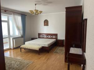 um quarto com uma cama, uma mesa e uma janela em Lux House em Chernivtsi