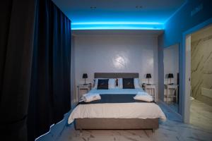 1 dormitorio con 1 cama grande y una iluminación azul en B&B Dolce Sosta en Nápoles