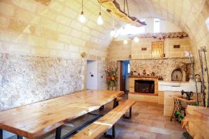 een grote eetkamer met een houten tafel en een open haard bij Villa Vinne Cirase in Castiglione dʼOtranto