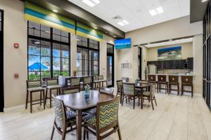 Un restaurante con mesas y sillas y una cocina. en Modern waterfront home in Artesia with pool/gym, en Lely Resort