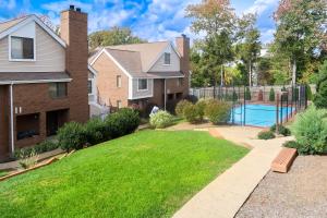 a house with a yard with a swimming pool at Tysons Corner Suites, A Baymont by Wyndham in Vienna