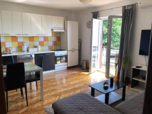 a kitchen and living room with a table and a couch at Apartment Bella Costa in Rijeka