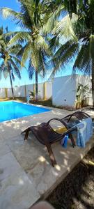 a hammock sitting next to a swimming pool at Pousada Graboschii, 300mt da praia do Refúgio in Aracaju