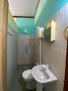 a bathroom with a white toilet and a sink at Lita Restaurante e Pousada in Porto de Sauipe