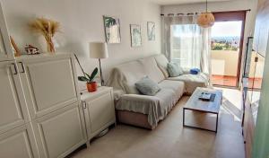 salon z kanapą i stołem w obiekcie Ático de ensueño, El Toyo, Almería - Playas, Golf, Cabo de Gata w mieście Retamar