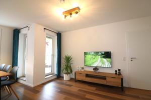 a living room with a flat screen tv on a wall at Moderne Wohnung mit Sauna nahe Burg im Spreewald in Vetschau