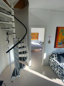 a room with a spiral staircase and a bedroom at Appartamento Lella con meravigliosa vista zona Corso Bagni in Acqui Terme