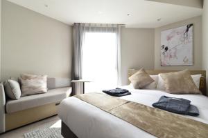 a bedroom with a bed and a couch and a window at Hotel Cordia Osaka Hommachi in Osaka