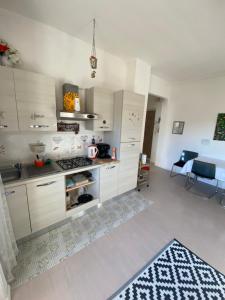 a kitchen with white cabinets and a stove at Appartamento Lella con meravigliosa vista zona Corso Bagni in Acqui Terme
