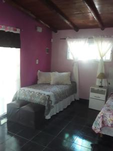 een slaapkamer met een bed en een paarse muur bij Nuestro Hogar in Malargüe