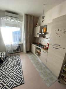 a kitchen with a refrigerator and a window in a room at Appartamento Lella con meravigliosa vista zona Corso Bagni in Acqui Terme