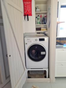 eine Waschmaschine und Trockner in einer Küche neben einer Tür in der Unterkunft Grindstugan Högbo in Sandviken