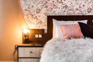 リヴィウにあるПростора квартира в центрі Львоваのベッド(白い掛け布団、ピンクの枕付)