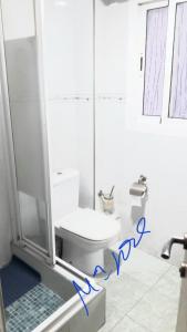 a bathroom with a toilet and a shower with blue writing at Piso en PLAYA malvarrosa a 7 minutos andando y universidades Valencia, Beach, Solo admito Familia con niños Tengo otro piso cerca in Valencia