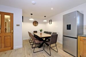 a kitchen and dining room with a table and a refrigerator at Rosebrae in Insch