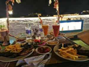 una mesa con platos de comida y bebidas. en PYRAMIDS TOP IN en El Cairo