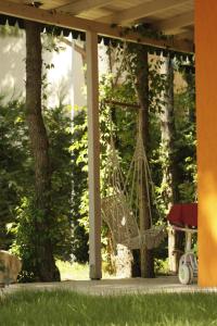 una hamaca colgada de un porche con árboles en Marea Resort, en Golem