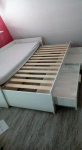 un letto bianco in una camera con pavimento in legno di cocon douillet avec ambiance du feu au bois a Hastière-par-delà