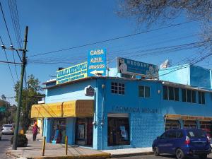 un bâtiment bleu au coin d'une rue dans l'établissement Casa Azul Aragon, à Mexico