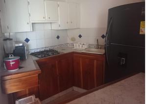 una cucina con armadi in legno e frigorifero nero di Condominio Victoria Real - Apartamento 202 a Puerto Viejo