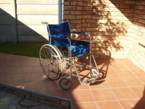 a blue wheelchair sitting outside of a house at Newton Sands Guesthouse in Port Elizabeth
