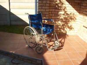 einem blauen Rollstuhl, der vor einem Haus sitzt in der Unterkunft Newton Sands Guesthouse in Port Elizabeth